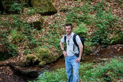 Portrait of young man standing against plants