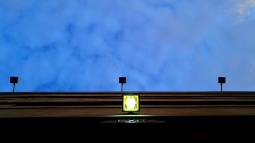 Low angle view of street light against blue sky