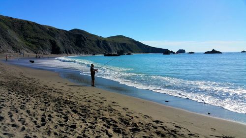 Man fishing in sea at beach