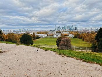 View of central london buildings against cloudy sky, from greenwich park