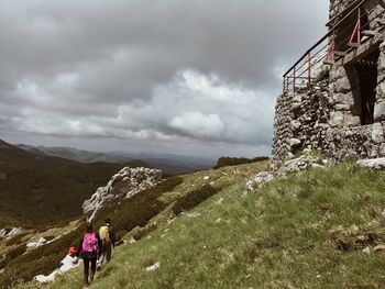 Rear view of people on mountain against sky