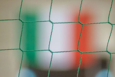 Close-up of green net against italian flag