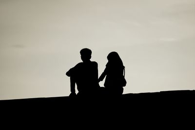 Low angle view of silhouette people at sunset