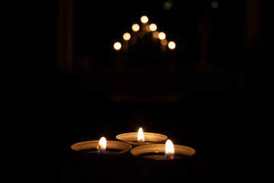 Close-up of burning candle against black background