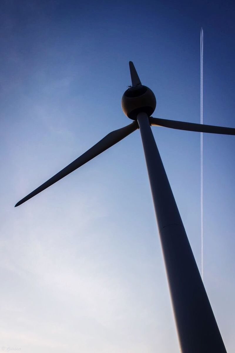 low angle view, blue, clear sky, sky, metal, fuel and power generation, wind turbine, no people, technology, day, copy space, outdoors, wind power, environmental conservation, tall - high, alternative energy, pole, renewable energy, metallic, street light