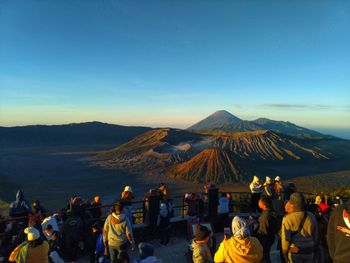 Group of people on mountain against sky