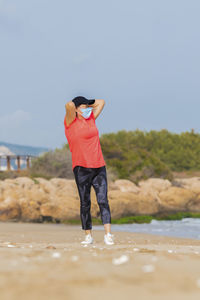 Rear view of woman standing on land against sky