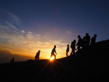 Silhouette people against sky during sunset