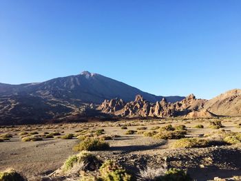 Scenic view of rocky mountains against clear blue sky