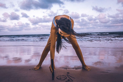 Woman at beach against sky