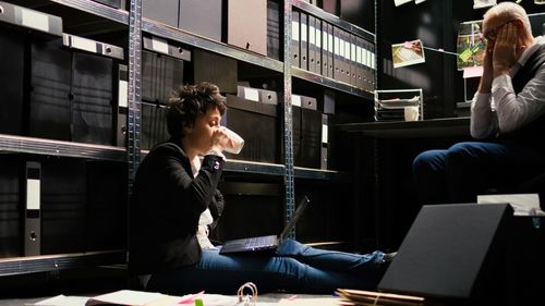 Side view of young woman using mobile phone while sitting in cafe