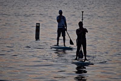 Man and woman paddleboarding on sea