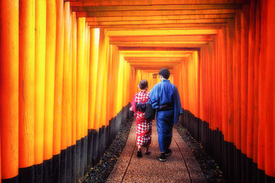 Rear view of men walking in temple amidst building