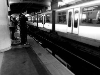 Rear view of woman standing on railroad station platform