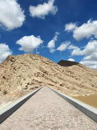 Road leading towards mountain against sky