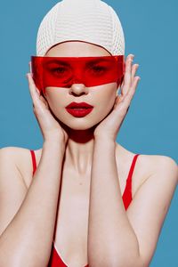 Portrait of woman wearing mask against blue background