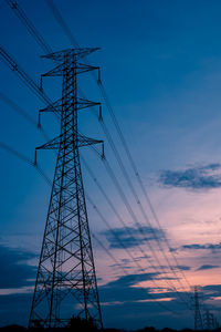 Low angle view of silhouette electricity pylon against sky