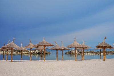 Parasols on beach against sky