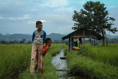 Boy standing on land against sky