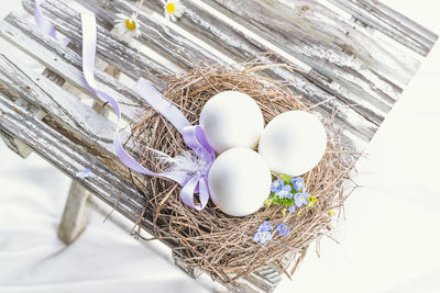 High angle view of eggs in nest by flowers on table