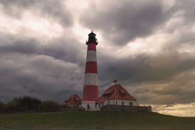 Lighthouse amidst buildings against sky