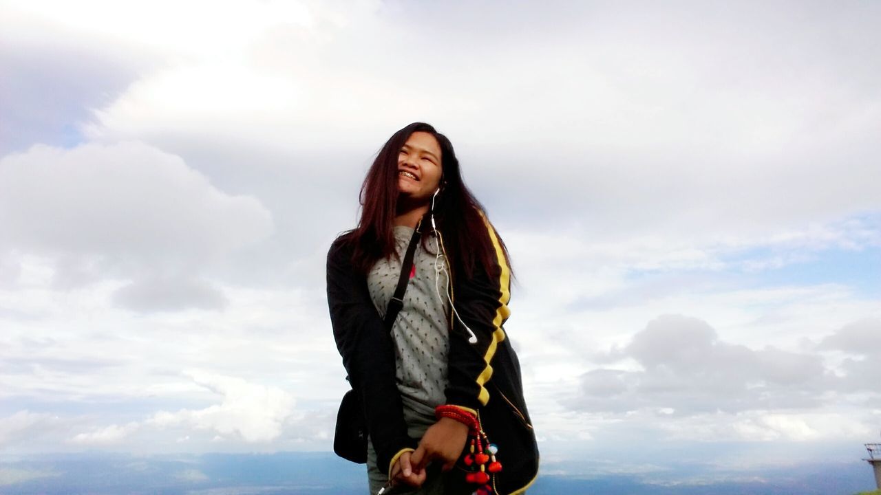 young adult, lifestyles, leisure activity, young women, person, casual clothing, sky, standing, three quarter length, looking at camera, front view, portrait, smiling, cloud - sky, sunglasses, low angle view, long hair