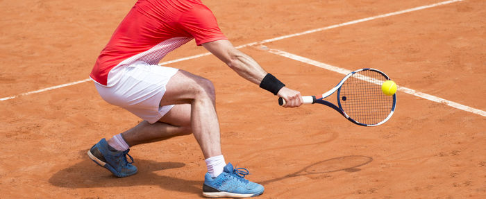 Midsection of man playing tennis