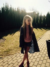 Full length of woman standing on footpath