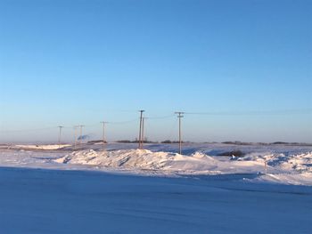 Snow covered land against clear blue sky at the train yard with my fav powerline