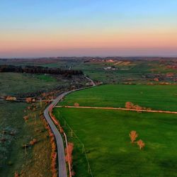 Scenic view of agricultural field against sky during sunset