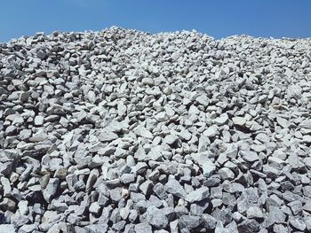 Close-up of stones on land against clear blue sky