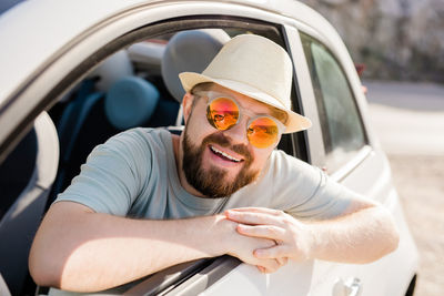 Low angle view of man wearing sunglasses while sitting in car