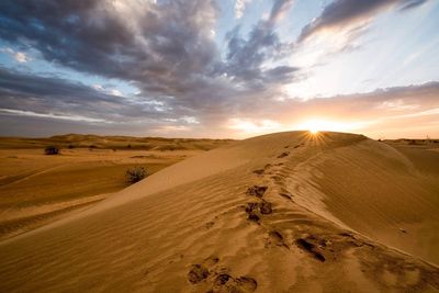 Scenic view of desert against sky during sunset