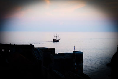 Sailboat on sea against sky during sunset