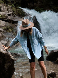 Rear view of woman standing on rock