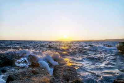 Scenic view of sea against clear sky during sunset