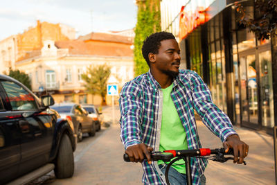Portrait of young man riding bicycle on street in city