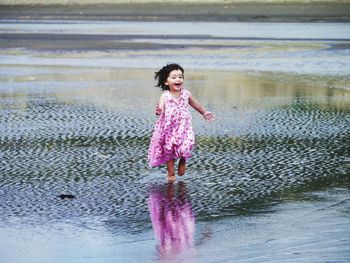 Full length of a happy woman standing in water