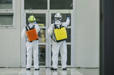 Two firefighters disinfecting the interior of a building