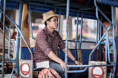 Portrait of young woman standing against bus