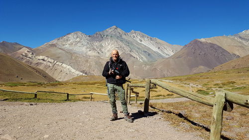 Man standing on mountain against clear blue sky