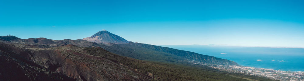 Scenic view of mountain against blue sky