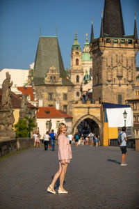 People walking in front of building against sky