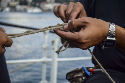 Close-up of hands holding a rope