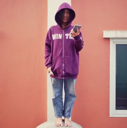 Portrait of boy standing against wall