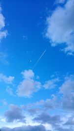 Low angle view of airplane against blue sky