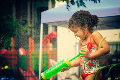 Cheerful girl playing with squirt gun