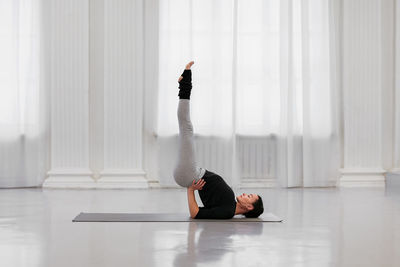 Midsection of woman doing yoga at home