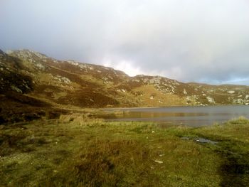 Scenic view of mountains against cloudy sky