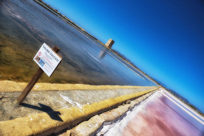 Low angle view of text on building against clear blue sky